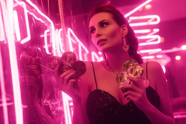 A glamorous woman holding casino chips in a neon-lit environment, representing the premium online casino atmosphere of GOOD111.